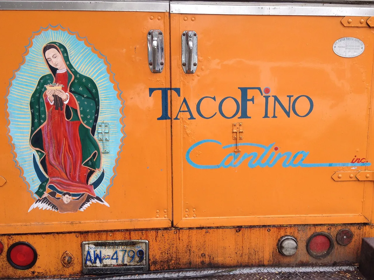 The orange Tacofino taco truck with its painted side